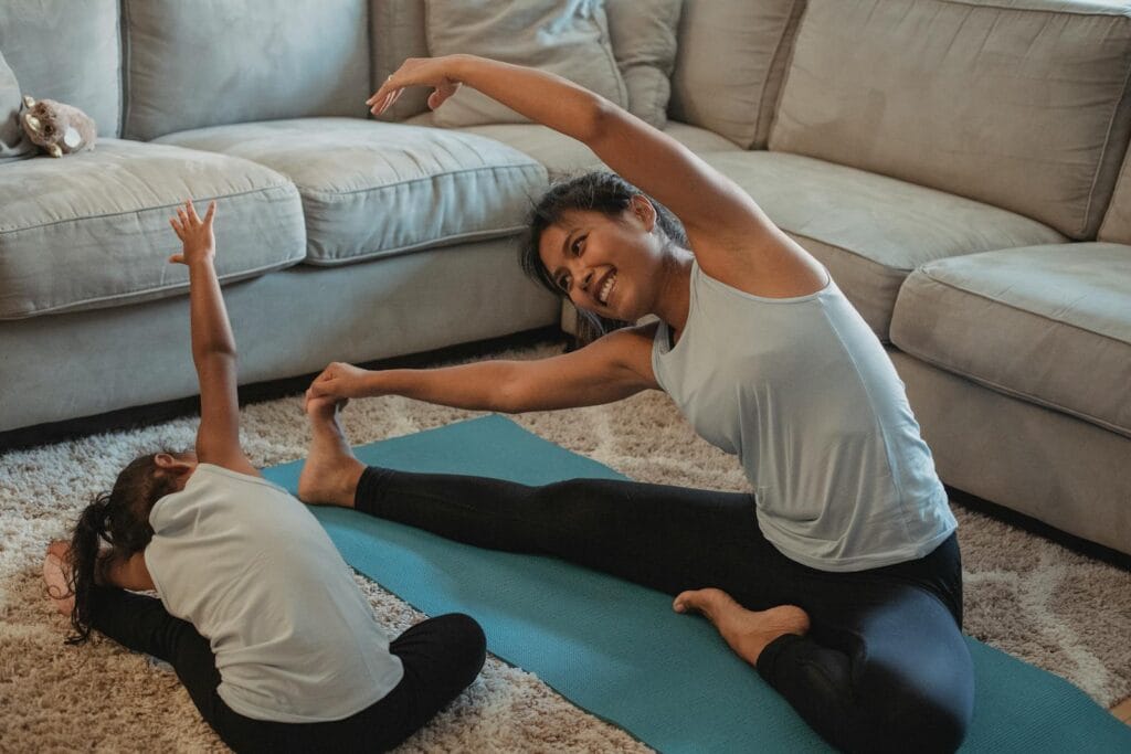 A joyful mother and daughter doing yoga in their living room, promoting a healthy lifestyle.