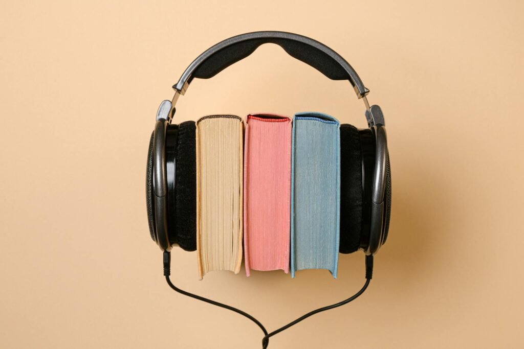 Stylish conceptual image of headphones and books on a beige background, symbolizing audiobooks.Do audiobooks legitimately count as quality literature?